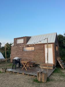 a tiny house with a deck and a grill at Tiny House Bord de Mer in Plouarzel