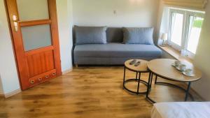 a living room with a couch and a table at Słoneczny Dom pokoje i apartament na wynajem in Łeba