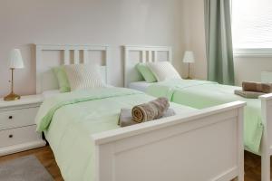 two beds in a bedroom with green and white at Move&Rest Slunj in Slunj