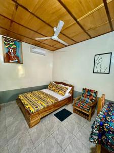 a bedroom with a bed and a chair in it at Hotel Eyram Kpalime in Palimé +24 photos