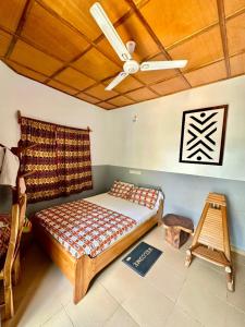 a bedroom with a bed and a ceiling fan at Hotel Eyram Kpalime in Palimé