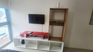 a room with a shelf and a tv on a wall at Departamento centro Parana 2 in Paraná