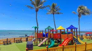 a playground at the beach with palm trees at Maceió Mar Hotel in Maceió