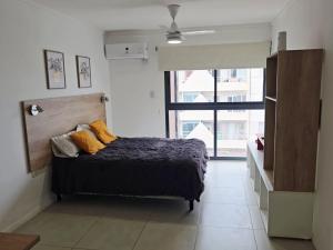 a bedroom with a bed and a large window at Departamento centro Parana 2 in Paraná