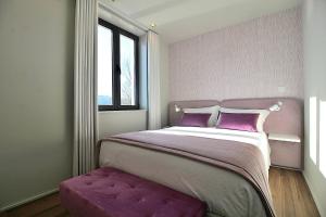 a bedroom with a large bed with purple cushions at RestOnDouro Oporto Flat in Valbom