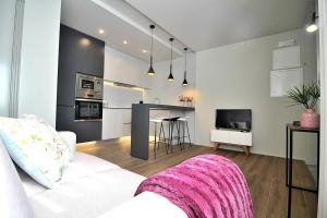 a living room with a white couch and a kitchen at RestOnDouro Oporto Flat in Valbom