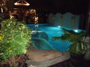 a swimming pool at night with plants at Baan Tropicana in Mae Nam