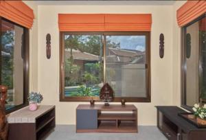 a living room with a table and a large window at Baan Tropicana in Mae Nam