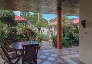 a patio with a table and chairs and trees at Baan Tropicana in Mae Nam