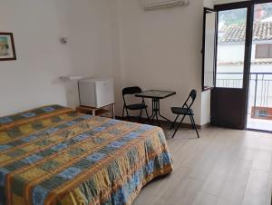 a bedroom with a bed and a table and chairs at Dentro Scopello - Casa Vacanze in Scopello +27 photos