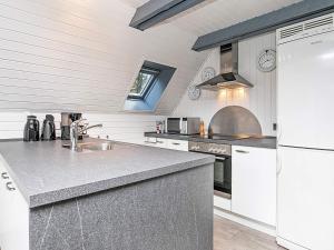 a kitchen with a sink and a white refrigerator at 6 person holiday home in Ringkøbing in Ringkøbing