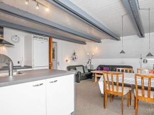 a kitchen and living room with a table and chairs at 6 person holiday home in Ringkøbing in Ringkøbing +31 photos