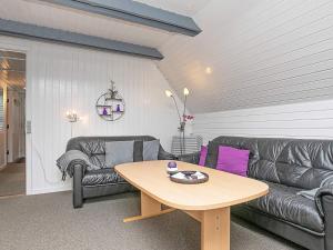 a living room with a leather couch and a table at 6 person holiday home in Ringkøbing in Ringkøbing