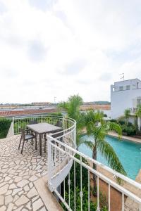 a patio with a table and a pool at Residence Le Piscine in Nardò