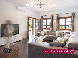 a living room with a couch and a tv at Spacious Private Villa up to 16 - Casa Quintero Yaiza - Volcano, Timanfaya park, Bodega & South Beaches - Heated Pool - Game Room - Charcoal grill in Yaiza +62 photos