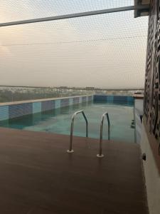 a swimming pool with two handles in the water at Atelier Sol- ultra luxe aparthotel near airport in Pune