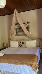 a bedroom with a bed with a canopy at Pousada Casagrande in Pirenópolis