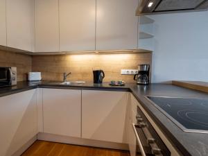 a kitchen with white cabinets and a sink at Premium Duplex 2BR for 6 with Balcony near City Museums Metro U3 U2 in Vienna