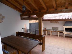 a patio with a wooden bench and a table at Casas Rurales las Eras III in Ayllón