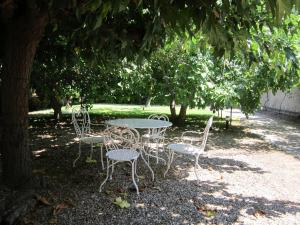 a group of tables and chairs under a tree at Havre de paix au bord de létang de Thau avec vue-magnifiques couchers de soleil-et accès direct et privé à l'eau-possibilité de se garer gratuitement dans la rue in Sète