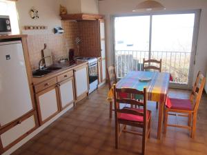 a kitchen with a table and chairs and a kitchen with a window at Havre de paix au bord de létang de Thau avec vue-magnifiques couchers de soleil-et accès direct et privé à l'eau-possibilité de se garer gratuitement dans la rue in Sète
