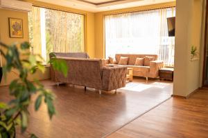 a living room with two couches and a large window at Хотелски комплекс Радецки град Козлодуй in Kozloduy