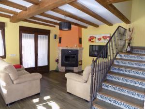 a living room with two chairs and a fireplace at Casas Rurales las Eras III in Ayllón