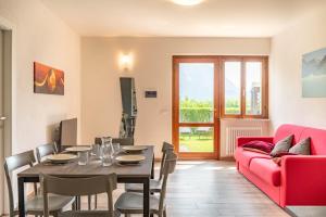 a living room with a table and a red couch at Casa Maria in Mezzolago