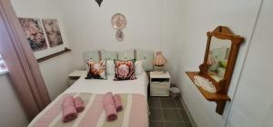 a bedroom with a bed with pink slippers on it at Abi se Nessie in Orania