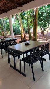 a wooden table with chairs and a table and a table and chairs at Pousada Villa Peruaçu - Na entrada do Parque Nacional Cavernas Peruaçu in Januária