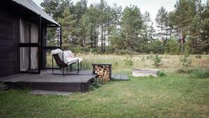 a chair sitting on a porch of a cabin at Drewutnia nad Hańczą in Sernetki