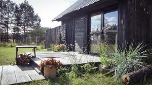 a cabin with a wooden porch and a window at Drewutnia nad Hańczą in Sernetki