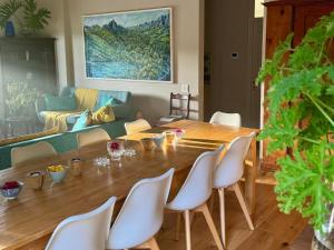 a living room with a wooden table and white chairs at Kamala Karoo Sanctuary in Barrydale
