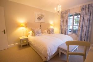 a bedroom with a white bed and a window at Exquisite Cottage Twenty in Knysna