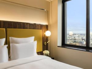a hotel room with a bed and a window at Pullman Paris Montparnasse in Paris +209 photos