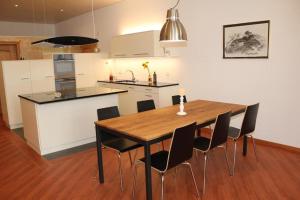 a kitchen and dining room with a wooden table and chairs at Toni's Alpine Loft & SPA in Kandersteg