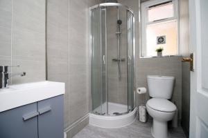 a bathroom with a shower and a toilet and a sink at Cathedral House by Tŷ SA in Newport