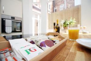 a box of food on a table with a glass of orange juice at Cathedral House by Tŷ SA in Newport