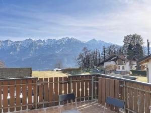 a deck with chairs and mountains in the background at Lagorai Wood Apartment in Telve