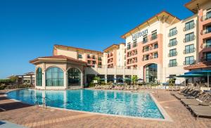 a hotel with a swimming pool in front of a building at Hilton Dallas/Rockwall Lakefront Hotel in Rockwall