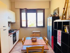 a kitchen with a table and a refrigerator and a window at ALT alloggio turistico in Focene