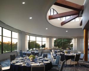 a banquet hall with tables and chairs and windows at Hilton Dallas/Rockwall Lakefront Hotel in Rockwall