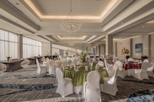 a banquet hall with white tables and chairs and a chandelier at Hilton Dallas/Rockwall Lakefront Hotel in Rockwall +97 photos