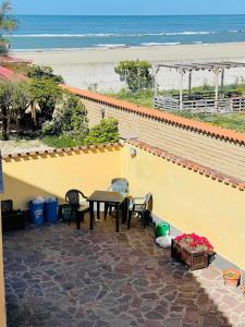 a patio with a table and chairs and the beach at ALT alloggio turistico in Focene