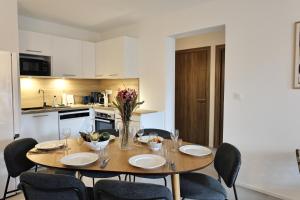 a dining room with a table and chairs and a kitchen at KerTerra Corsica - Apt 3 chambres - Piscine & plage privée in Pianottoli-Caldarello