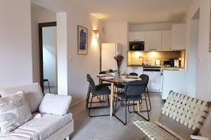 a living room and kitchen with a table and chairs at KerTerra Corsica - Apt 3 chambres - Piscine & plage privée in Pianottoli-Caldarello