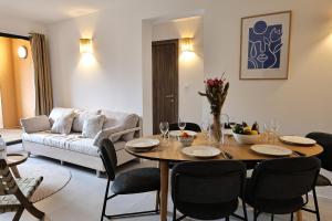 a living room with a table and chairs and a couch at KerTerra Corsica - Apt 3 chambres - Piscine & plage privée in Pianottoli-Caldarello +40 photos