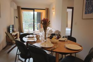 a dining room with a table with chairs and a table at KerTerra Corsica - Apt 3 chambres - Piscine & plage privée in Pianottoli-Caldarello