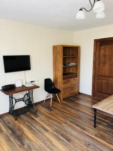 a room with a desk and a television and a chair at Old Willows in Ventspils
