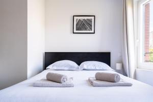 a bedroom with a white bed with two pillows at Premier Acte - Chambre Spacieuse Sur Les Allées in Toulouse